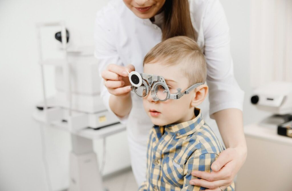 An eye doctor performing an eye exam on a child by changing the lens type.