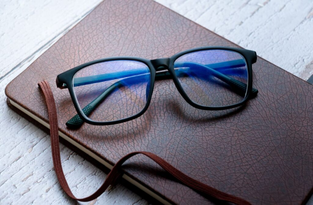 a pair of blue light glasses on a leather notebook.