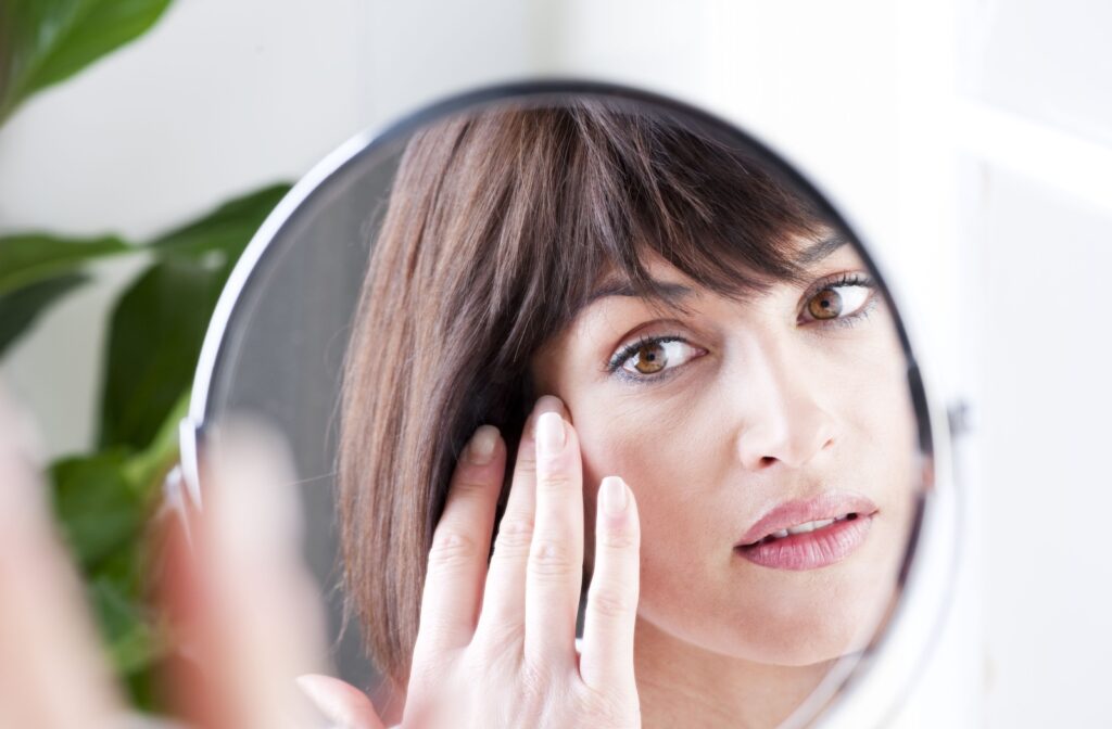 woman looking into the mirror at her eye